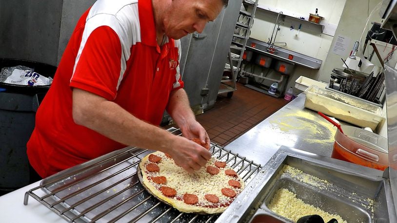 Kenneth Couch, the general manager of Slice of Heaven Pizzeria, makes a pizza in the restaurant’s kitchen Wednesday. Slice of Heaven has won several awards in the past at the Enon Pizza Festival. He will try again this Saturday during the 5th annual event. BILL LACKEY/STAFF