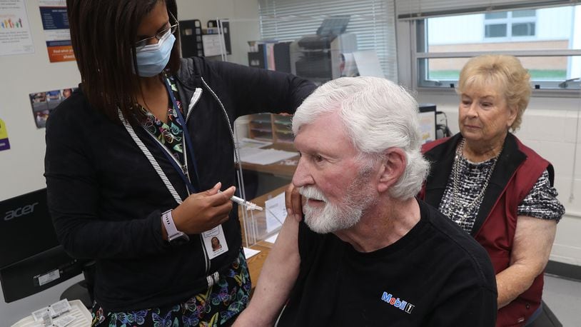 Clark County Combined Health District nurse Salimah Berrien gives Jack Sayers his flu vaccine as his wife, Nancy, waits her turn Wednesday, Oct. 19, 2022. BILL LACKEY/STAFF