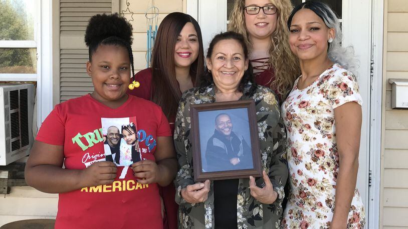 Angela Bowshier and her grandchildren hold photos of her late long-time boyfriend Jesse Clark, who along with Angela helped raise their family in her Fuller Center home, which she paid off in August. They are, left to right: Akeela Crossley, Tamika Rogan, Bowshier, Julie Rogan and India Rogan. Not pictured is Kylen Harrison. CONTRIBUTED