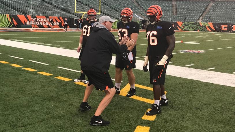 Bengals offensive line coach Frank Pollack goes over technique with several players during Saturday’s practice at Paul Brown Stadium. JAY MORRISON/STAFF