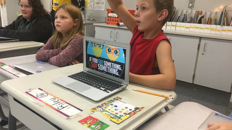 Riley Allen, a third grader at Kenwood Elementary School, raises his hand to answer a question during a “Say Something See Something” presentation last week.