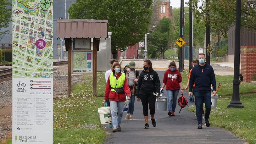 A group of volunteers clean up along the bike path in downtown Springfield Friday for Clark County Service Day. BILL LACKEY/STAFF