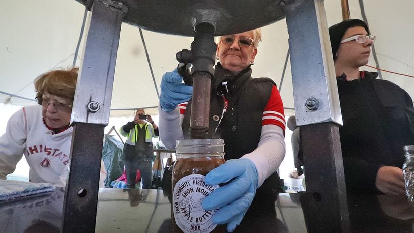Volunteers fill jars of hot apple butter Saturday, Oct. 8, 2022 at the Enon Apple Butter Festival. BILL LACKEY/STAFF