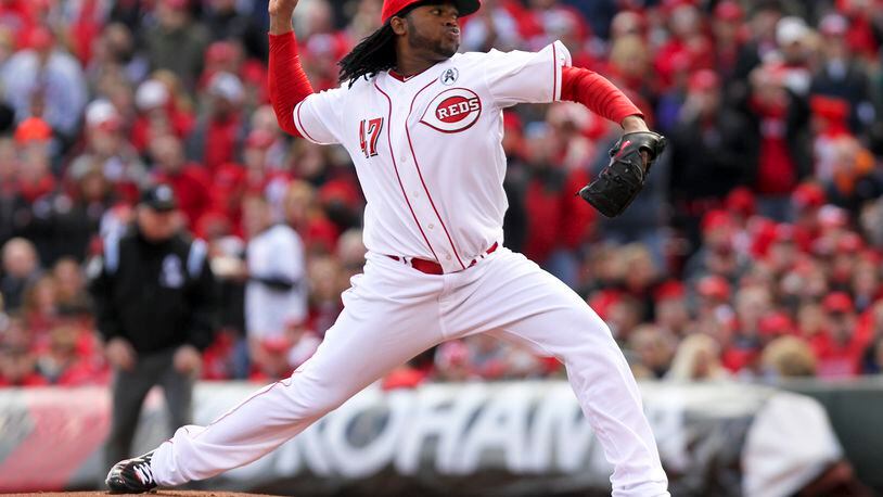Reds starting pitcher Johnny Cueto delivers the first pitch of the Reds season during their opening day game against the Angels at Great American Ball Park, Monday, April 1, 2013. GREG LYNCH / STAFF