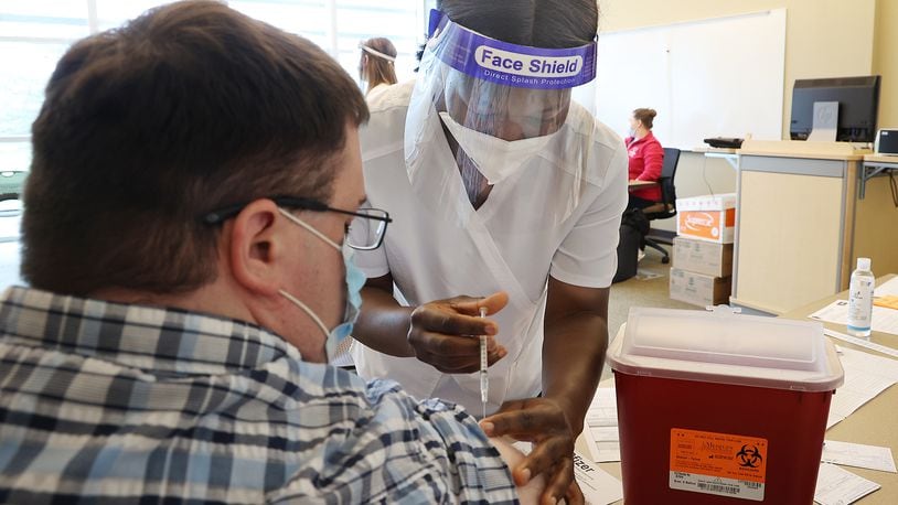 Clark State College's nursing program was granted full approval by the Ohio Board of Nursing. Here, Vivian Adu, a nursing student at Clark State College, gave Andrew Deans a COVID vaccine injection during a clinic at the college last year. BILL LACKEY/STAFF