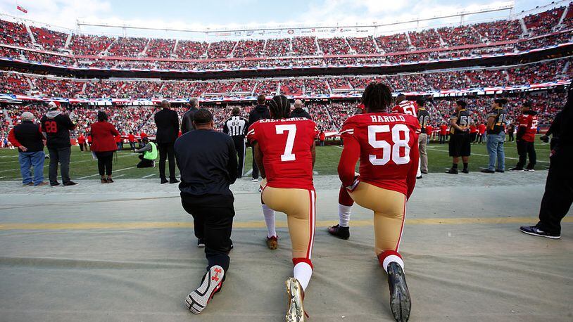Colin Kaepernick (7) takes a knee before a game in January.