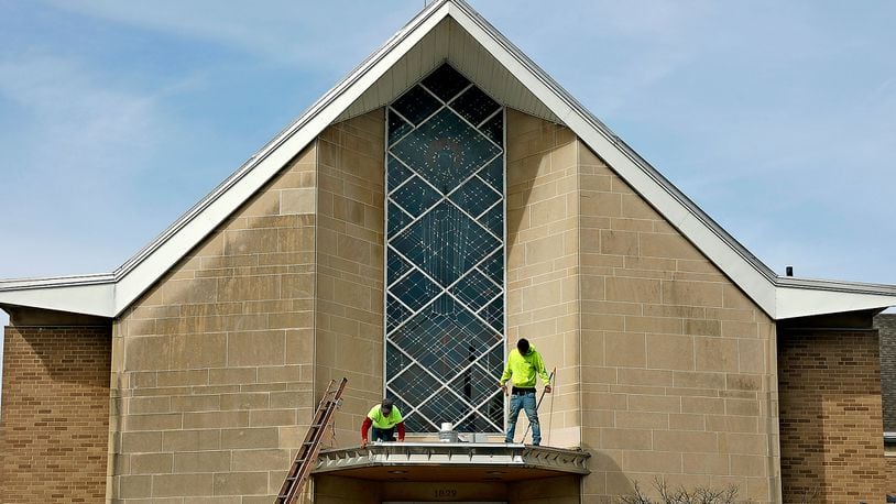 Workers were repairing the awning above the front doors of St. Teresa Catholic Church along North Limestone Street in Springfield on Thursday, March 16, 2023, when temperatures reached into the 60s. BILL LACKEY/STAFF
