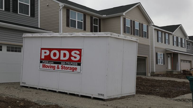 A moving and storage unit in a driveway at the new Ryan Homes housing project on Tuttle Road. BILL LACKEY/STAFF