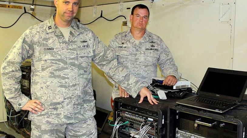 Col. Norman Poklar, of the Ohio Air National Guards 251st Cyber Engineering Installation Group and Capt. Craig Conner, of the 269th Combat Communications Squadron, point toward Joint Incident Site Communication Capability equipment that would be used in case of a natural disaster like Hurricane Katrina. Jeff Guerini/Staff