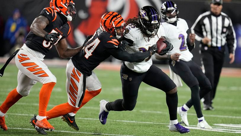 Baltimore Ravens running back Gus Edwards is stopped by Cincinnati Bengals safety Vonn Bell (24) in the first half of an NFL wild-card playoff football game in Cincinnati, Sunday, Jan. 15, 2023. (AP Photo/Darron Cummings)