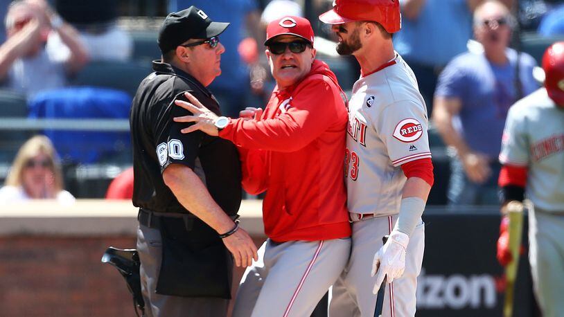 NEW YORK, NEW YORK - MAY 02:  David Bell #25 of the Cincinnati Reds get inbetween Jesse Winker #33 and umpire Marty Foster #60 after Jesse Winker was thrown out of the game for arguing a strike call in the eighth inning against the New York Mets at Citi Field on May 02, 2019 in New York City. (Photo by Mike Stobe/Getty Images)