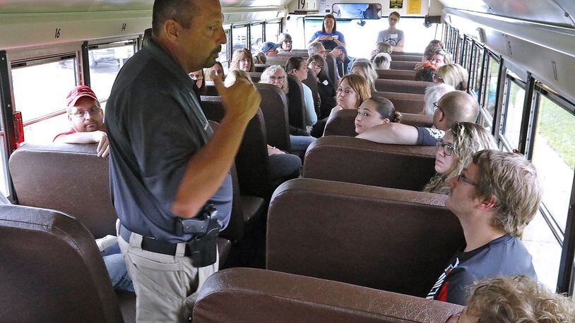 Springfield City School District Safety and Security Coordinator David Lyle talks to a group of bus drivers from throughout Clark County about a shooting scenario they just went over on a bus Monday at Indian Valley School. Bill Lackey/Staff