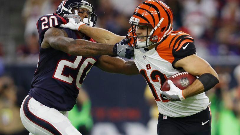 HOUSTON, TX - DECEMBER 24: Alex Erickson #12 of the Cincinnati Bengals gives a stiff arm to Don Jones #20 of the Houston Texans on a punt return in the second quarter at NRG Stadium on December 24, 2016 in Houston, Texas. (Photo by Tim Warner/Getty Images)