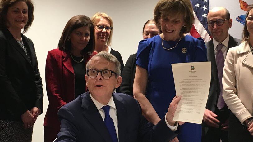 Gov. Mike DeWine signs an executive order to set up a panel of experts on how to improve Ohio’s home visit program for at-risk pregnant women, new moms and their babies. Photo by Laura Bischoff