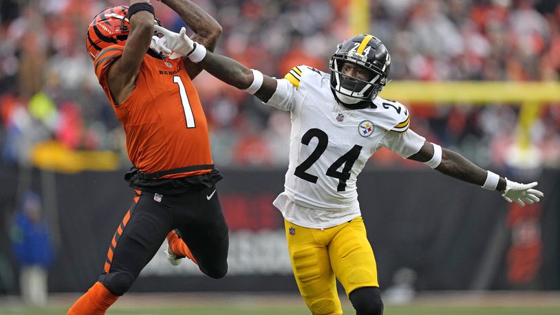 Cincinnati Bengals wide receiver Ja'Marr Chase (1) catches a pass from quarterback Jake Browning for a first down with Pittsburgh Steelers cornerback Joey Porter Jr. (24) defending during the second half of an NFL football game in Cincinnati, Sunday, Nov. 26, 2023. (AP Photo/Carolyn Kaster)
