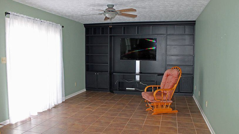 The focal point of the family room is a floor-to-ceiling shelving and entertainment center along the far wall.