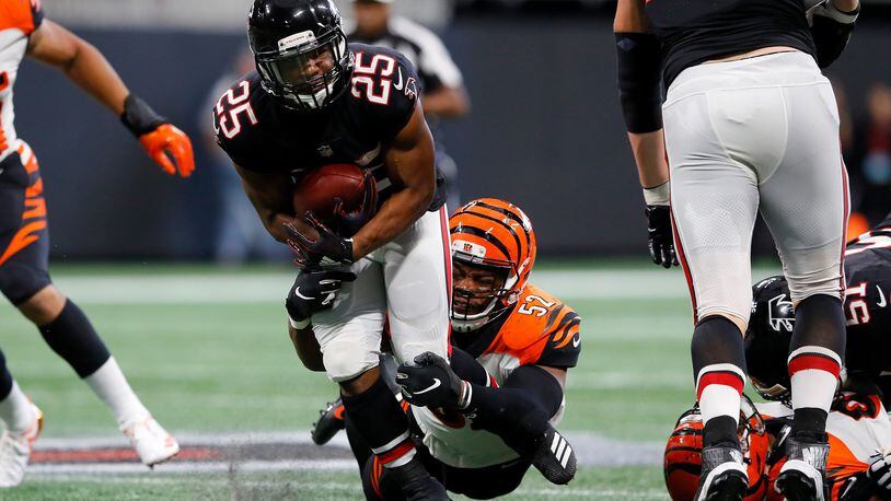 ATLANTA, GA - SEPTEMBER 30: Ito Smith #25 of the Atlanta Falcons is tackled by Preston Brown #52 of the Cincinnati Bengals during the third quarter at Mercedes-Benz Stadium on September 30, 2018 in Atlanta, Georgia. (Photo by Kevin C. Cox/Getty Images)