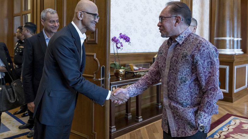 In this photo provided by Malaysia Prime Minister Office, Malaysia's Prime Minister Anwar Ibrahim, right, shakes hands with Microsoft CEO Satya Nadella at the prime minister's office in Putrajaya, Malaysia, Thursday, May 2, 2024. (Albarra Azfar/Prime Minister's Office of Malaysia via AP)