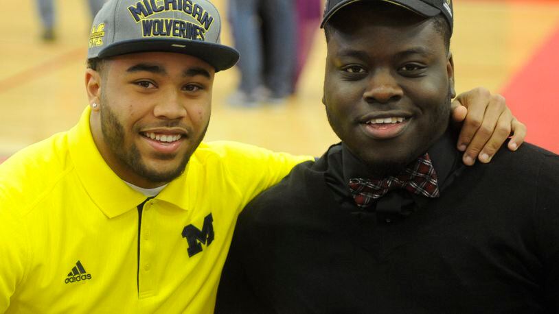 Wayne High School teammates Tyree Kinnel (left, University of Michigan) and Robert Landers (Ohio State) during National Signing Day ceremony at the school on Wednesday, Feb. 4, 2015. MARC PENDLETON / STAFF