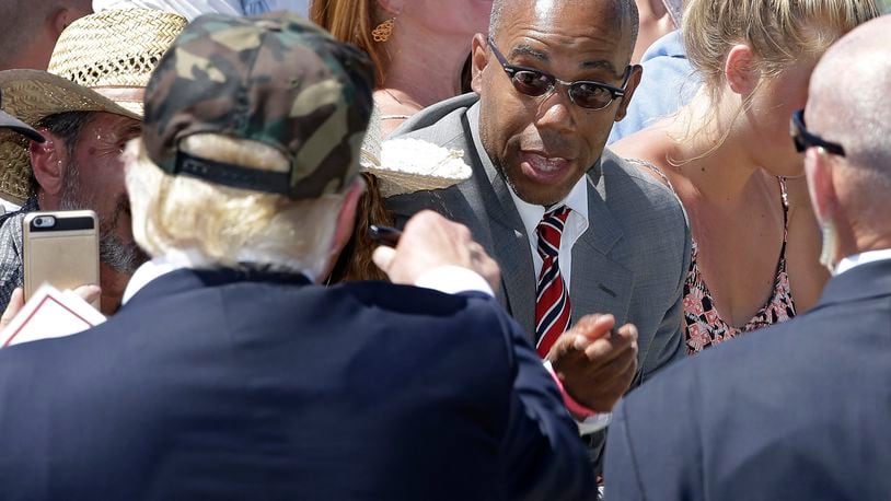 In this photo taken June 3, 2016, Republican presidential candidate Donald Trump, left, talks to Gregory Cheadle as he leaves a campaign rally at the Redding Municipal Airport, in Redding, Calif.