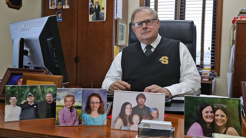 Gregg Morris is surrounded by pictures of his children and grandchildren in his office Wednesday. Morris is retiring as Shawnee Schools superintendent after seven years at the end of this school year. Bill Lackey/Staff