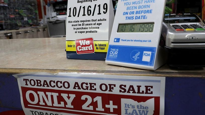 Signs on the counter at the Plum Food Mart in Springfield inform customers that they must by 21-years-old to purchase tobacco and vaping products as of Wednesday, Oct. 16, 2019. BILL LACKEY/STAFF
