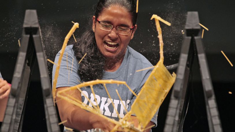 Springfield News-Sun Photographer Bill Lackey won first place feature photo for this image. Rochelle Fernando, from Fairborn High School, reacts as her noodle bridge collapses during the Engineering Innovation Bridge Competition at Clark State Community College in Springfield. Teams comprised of students int the Engineering Innovation program, sponsored by Clark State and Johns Hopkins University, built bridges with 250 grams for pasta and epoxy. The bridges then were compared to see how much weight they could hold before they broke. The winning bridge held 30 pounds. Bill Lackey/Staff