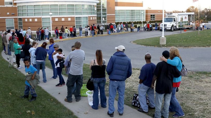 A line of people waiting for the Mobile Food Pantry wraps around part of the parking lot at Clark School Friday. Bill Lackey/Staff
