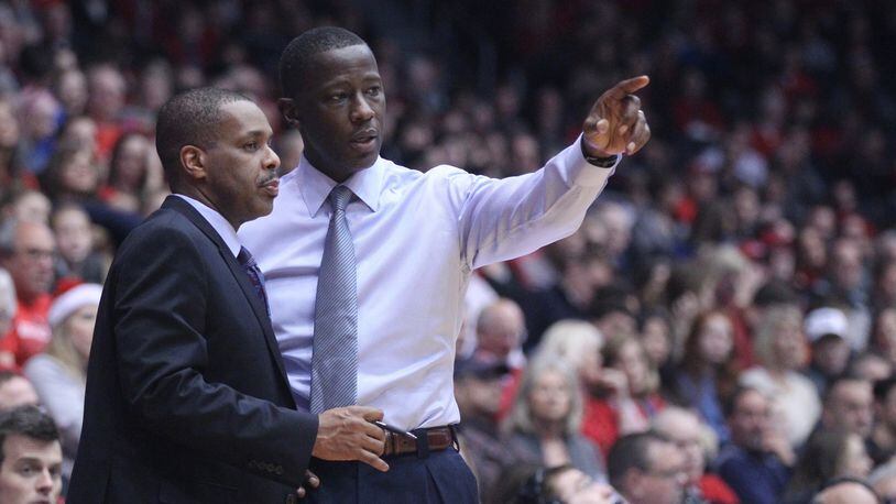 Dayton head coach Anthony Grant, right, talks to assistant coach  Anthony Solomon during a game against Wagner on Dec. 23, 2017, at UD Arena.