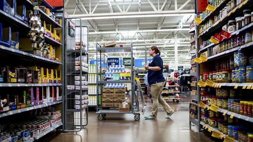 Ashley VanHorn, a grocery department dry goods manager, stocks shelves at the Walmart in Fulton, N.Y. Walmart is now using robots to help stock shelves at 50 stores across the country. (Roger Kisby/The New York Times)
