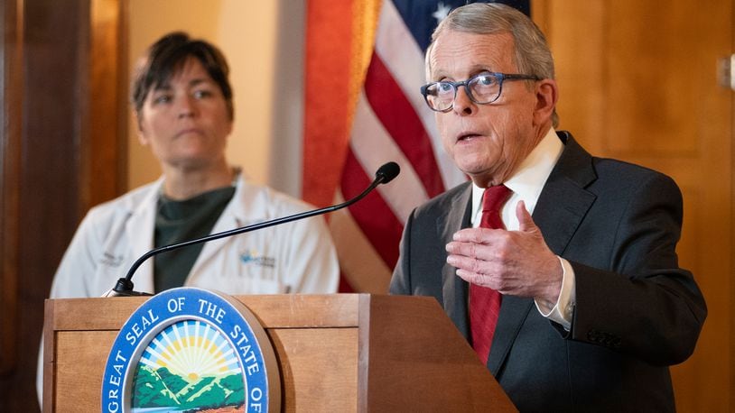 Ohio Gov. Mike DeWine speaks during a news conference as Dr. Sara Bode of Nationwide Children's Hospital stands behind him after he vetoed legislation that would have blocked cities like Columbus from banning the sale of menthol cigarettes and flavored vapes, Thursday, Jan. 5, 2023. (Brooke LaValley/The Columbus Dispatch via AP)