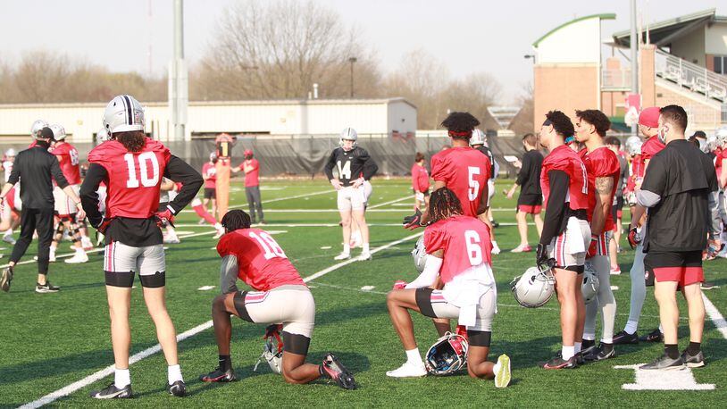 Freshman QB Kyle McCord (center, in black jersey) gets some coaching during Ohio State football practice Monday, April 5, 2021, in Columbus.