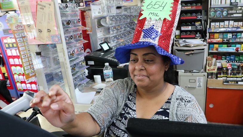 Hiral Patel was wearing a hat announcing the amount of the Mega Millions lottery Tuesday at the Plum Food Mart. The Mega Millions lottery drawing is tonight and the jackpot is $654 million. BILL LACKEY/STAFF
