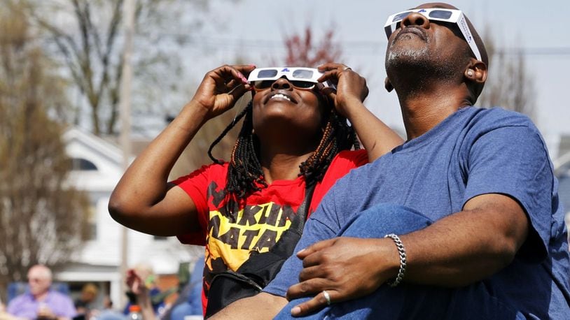 Ema and Antonio Grady, from Cincinnati, watch the total solar eclipse Monday morning, April 8, 2024 at Marcum Park in Hamilton. NICK GRAHAM/STAFF