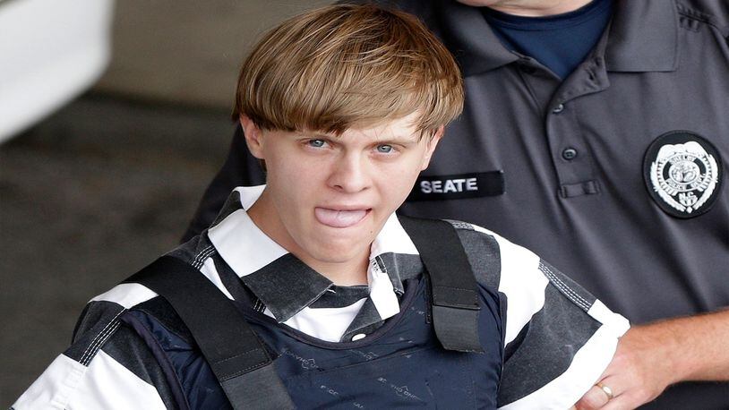 In this Thursday, June 18, 2015, file photo, Charleston, S.C., shooting suspect Dylann Storm Roof is escorted from the Cleveland County Courthouse in Shelby, N.C. The families of some of the nine people killed in a South Carolina church are suing the FBI. Their lawsuit accuses the federal government of errors that enabled Dylann Roof to buy the .45-caliber handgun used in the June 2015 shootings at Emanuel AME Church in Charleston.