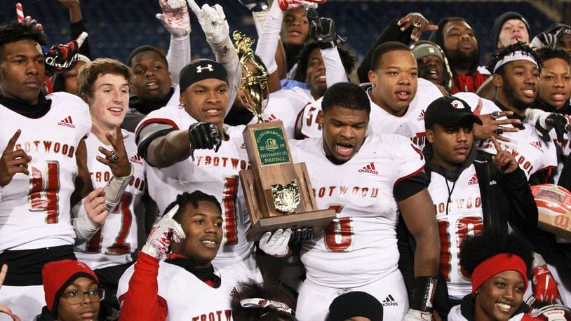 Trotwood-Madison twin brothers Keon’tae (left) and Ke’Shawn Huguely (both holding trophy) celebrate with teammates. Trotwood defeated Mansfield Senior 14-7 in overtime to win the Division III high school football championship at Tom Benson Hall of Fame Stadium in Canton on Friday. It was the Rams’ (12-3) third football state title, along with its 2011 and ‘17 championship teams. Anna also won a D-VI title on Friday and Marion Local will bid for the D-VII state title on Saturday. MARC PENDLETON / STAFF