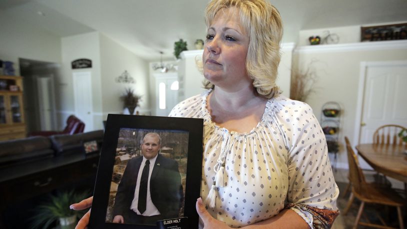 In this July 13, 2016 file photo, Laurie Holt holds a photograph of her son Josh Holt at her home, in Riverton, Utah.  Josh Holt  has been released from a jail in Venezuela after spending nearly two years behind bars on weapons charges.