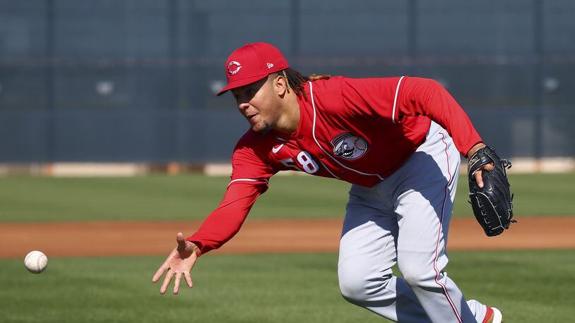 Cincinnati Reds starting pitcher Luis Castillo flips the ball to home plate during spring training baseball workouts Monday, Feb. 17, 2020, in Goodyear, Ariz. (AP Photo/Ross D. Franklin)