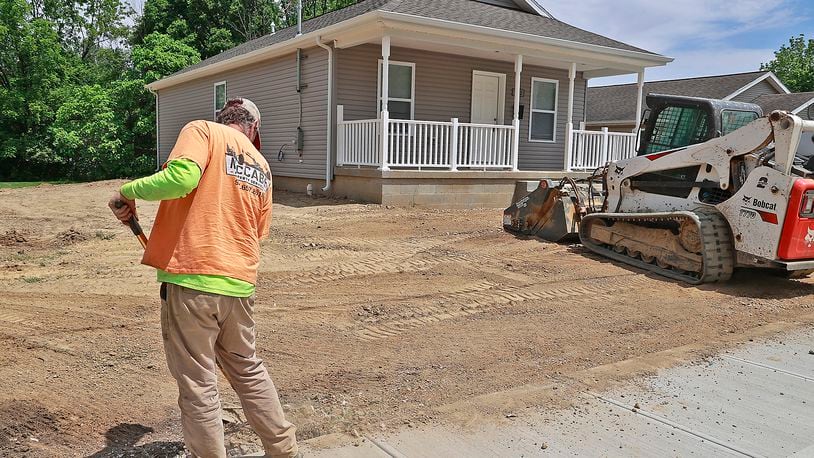 A worker from McCabe Property Services gets the ground around a new Habitat for Humanity house at 1122 W. Perrin Avenue ready for grass Thursday, May 25, 2023. BILL LACKEY/STAFF