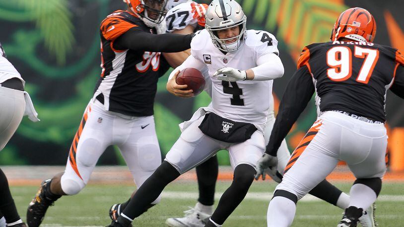 CINCINNATI, OH - DECEMBER 16: Derek Carr #4 of the Oakland Raiders attempts to run the ball past Geno Atkins #97 of the Cincinnati Bengals during the fourth quarter at Paul Brown Stadium on December 16, 2018 in Cincinnati, Ohio. Oakland defeated Cincinnati 30-16. (Photo by John Grieshop/Getty Images)
