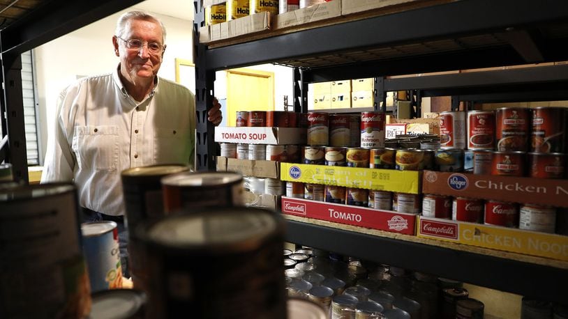 Bill Miller, the president of the Champaign County Memorial Foundation, looks over the food in the Oasis of Mercy Food Pantry in Mechanicsburg. Bill Lackey/Staff