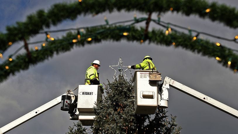 Two City of Springfield workers decorating the Springfield Holiday Tree in downtown Springfield in 2020. BILL LACKEY/STAFF