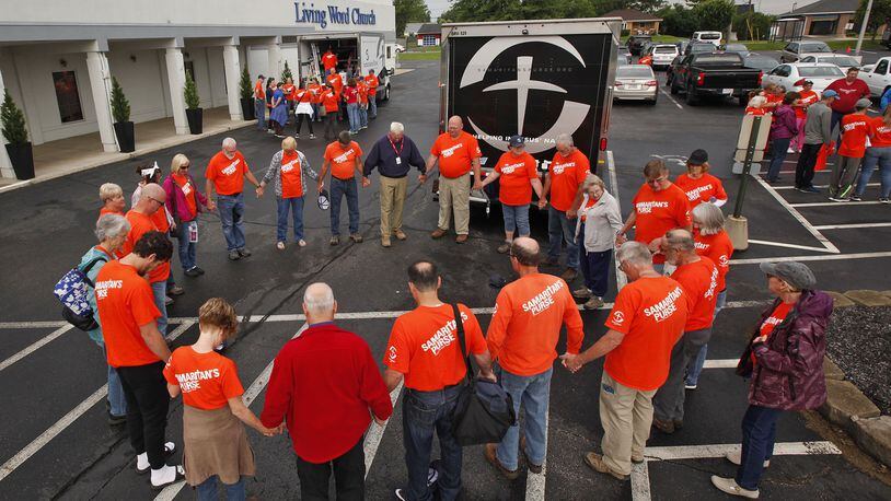 Volunteers with Samaritan’s Purse gather for prayer before going to tornado damaged neighborhoods in the Dayton area to assist homeowners. TY GREENLEES / STAFF