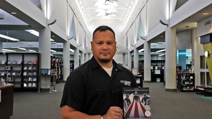 Chris Bussler holds his book in the Clark County Library Wednesday, Oct. 10, 2018. Bussler will be having a book signing at the library on November 7. BILL LACKEY/STAFF