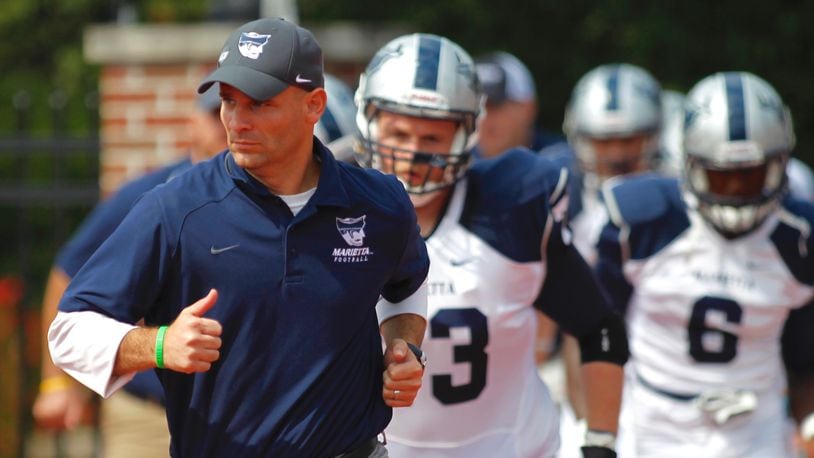 Marietta College head football coach Andy Waddle, a Greenon High School graduate and former defensive coordinator at Wittenberg, leads his team onto the field before a game at Otterbein on Saturday, Sept. 20, 2014, in Westerville. David Jablonski/Staff