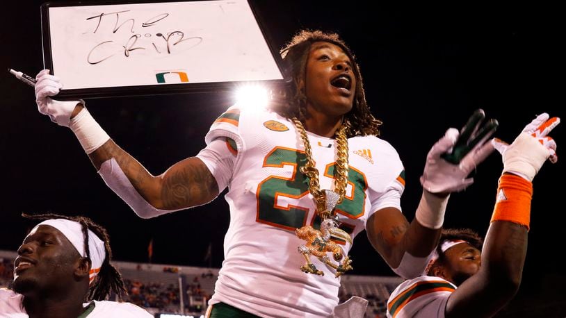CHARLOTTESVILLE, VA - OCTOBER 13: Sheldrick Redwine #22 of the Miami Hurricanes celebrates with the turnover chain in the first half during a game against the Virginia Cavaliers at Scott Stadium on October 13, 2018 in Charlottesville, Virginia. (Photo by Ryan M. Kelly/Getty Images)