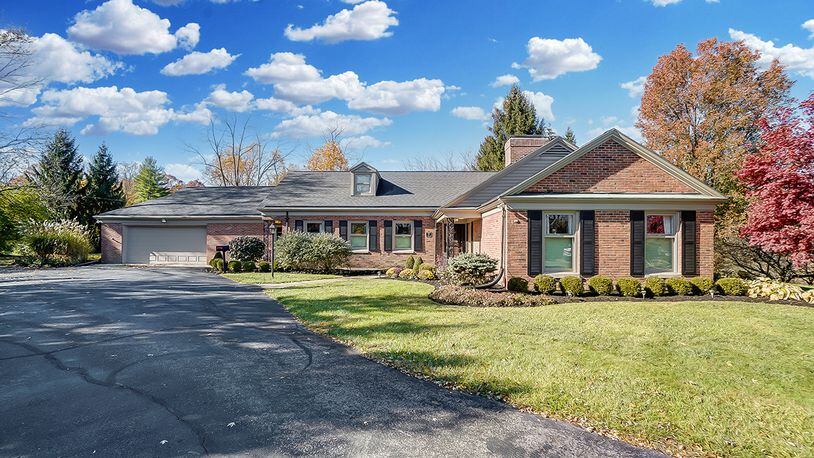 The 3-bedroom brick ranch on a wooded lot offers about 3,580 sq. ft. of living space. A driveway leads to the 2-car garage, a concrete walk and covered patio. CONTRIBUTED PHOTO