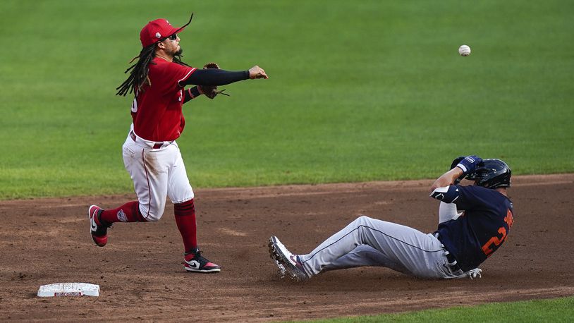Cincinnati Reds shortstop Freddy Galvis (3) throws to first for the double play the second inning of the exhibition game against the Detroit Tigers at Great American Ballpark in Cincinnati, Wednesday, July 22, 2020. (AP Photo/Bryan Woolston)