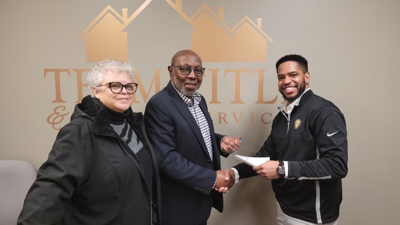 Urban Light Ministries co-founders, from left, Judy and Eli Williams turn over the deed to the ministry's former offices to Karlos L. Marshall, co-founder of The Conscious Connect CDC after closing on the deal on Jan. 18. ULM has a new office at Commerce Pointe and The Conscious Connect is expanding into Clark County. CONTRIBUTED PHOTO