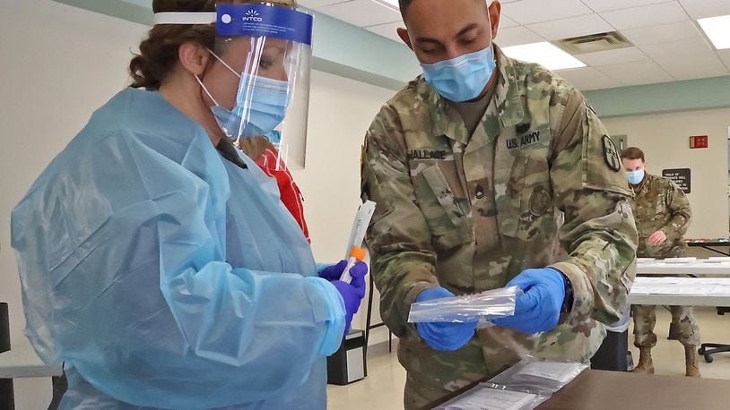 Renee Steele, from the Clark County Combined Health District, and SFC David Wallace of the Army National Guard discuss a patients COVID test inJanuary at the Clark County Combined Health District's Testing Center on East High Street. BILL LACKEY/STAFF